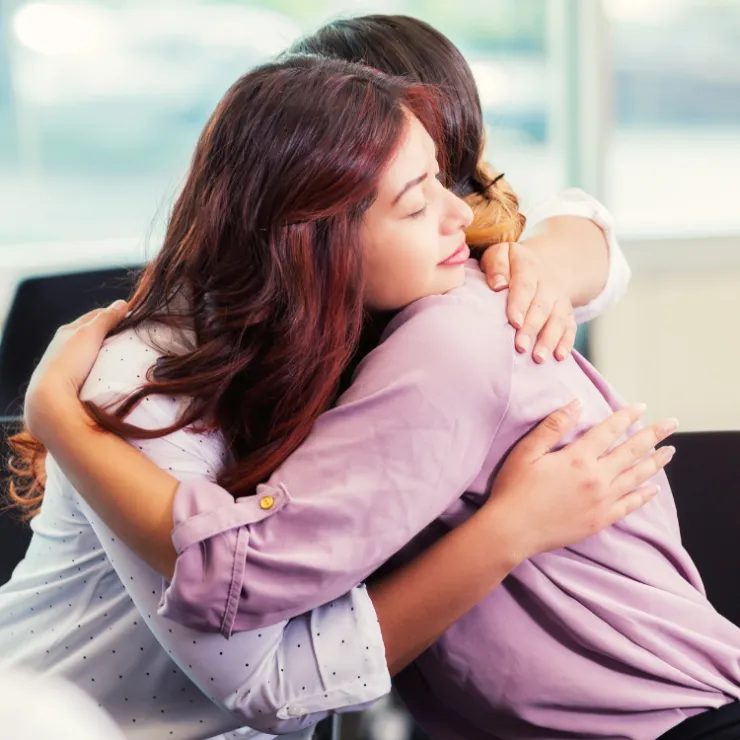 two employees hugging